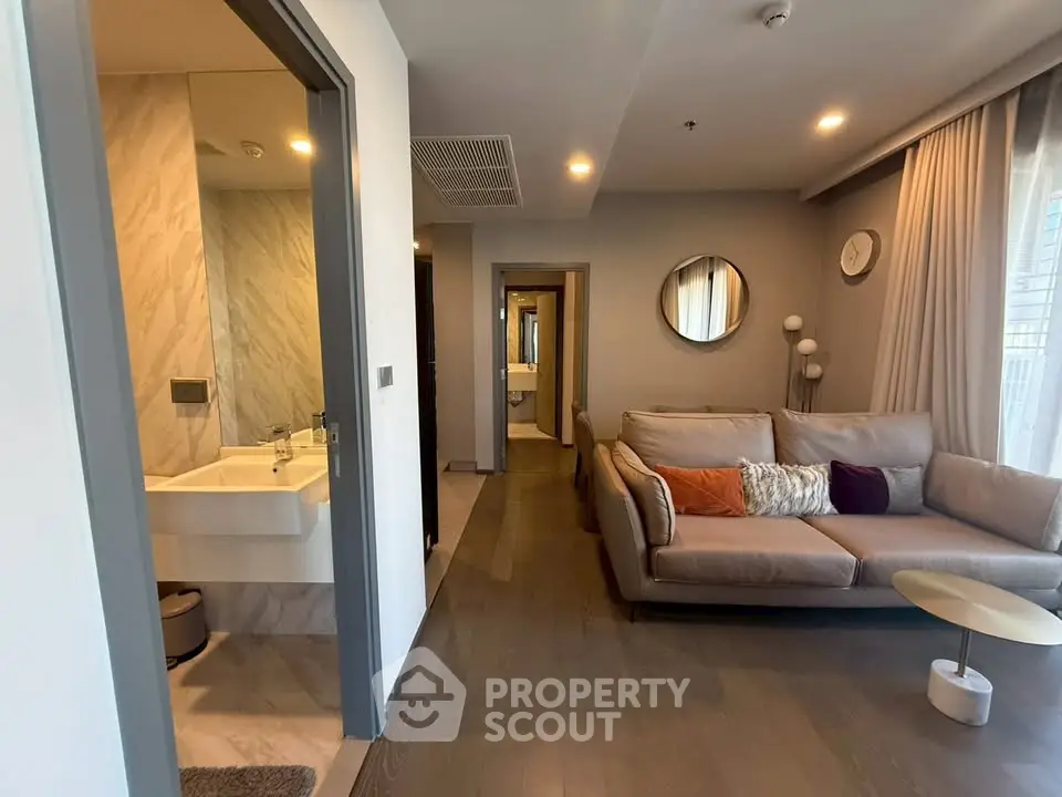 Modern living room with cozy sofa and adjacent bathroom in stylish apartment