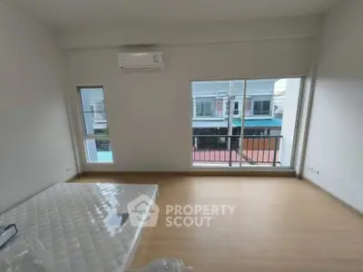 Spacious unfurnished bedroom with large windows and air conditioning unit.