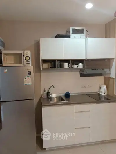 Modern kitchen with sleek cabinetry and stainless steel appliances in a compact layout.