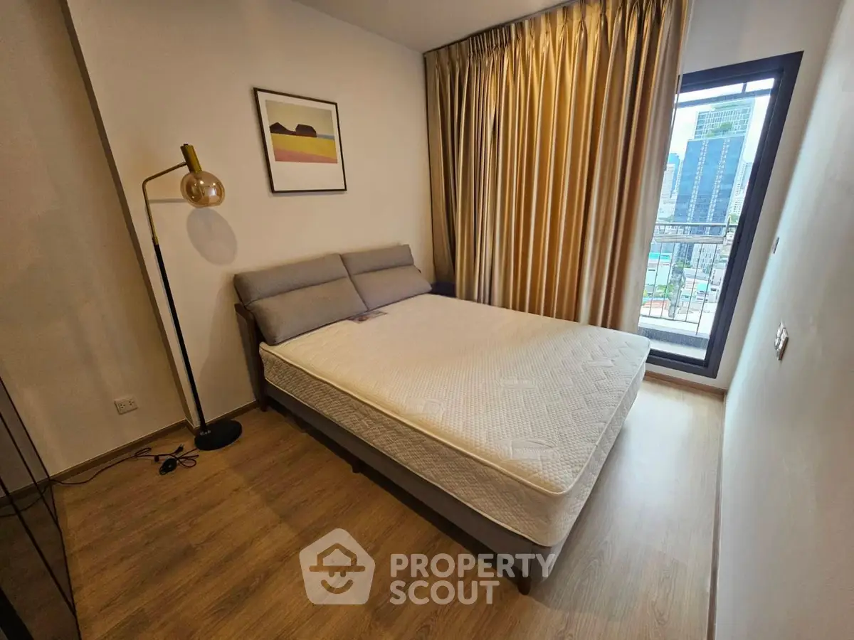 Modern bedroom with city view, featuring a cozy bed and stylish decor in a high-rise apartment.