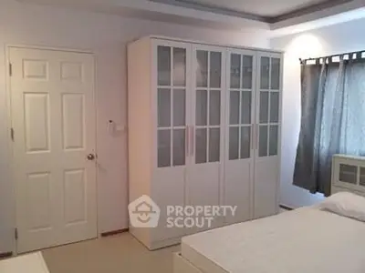 Spacious bedroom with modern wardrobe and natural light