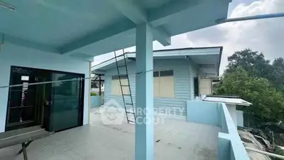 Spacious rooftop terrace with modern blue exterior and scenic views.