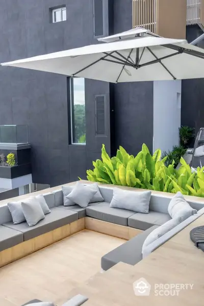 Modern outdoor seating area with stylish furniture and lush greenery