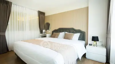 Elegant bedroom with stylish decor and natural light, featuring a plush bed and modern furnishings.