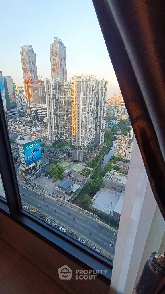 Stunning cityscape view from high-rise window showcasing modern architecture and bustling urban life.