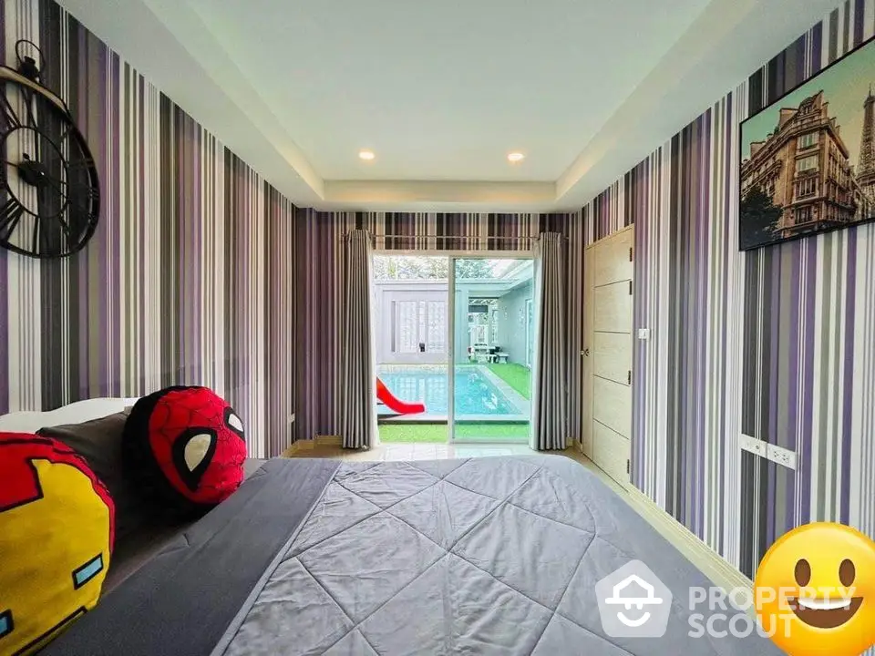 Charming bedroom with direct pool access, adorned with playful superhero cushions and stylish striped wallpaper, perfect for modern living.