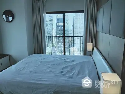 Modern bedroom with large bed, sleek design, and expansive city view through floor-to-ceiling windows leading to a balcony.