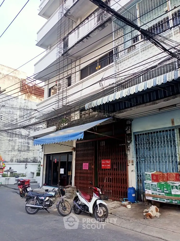 Street view of urban residential building with motorbikes parked outside.