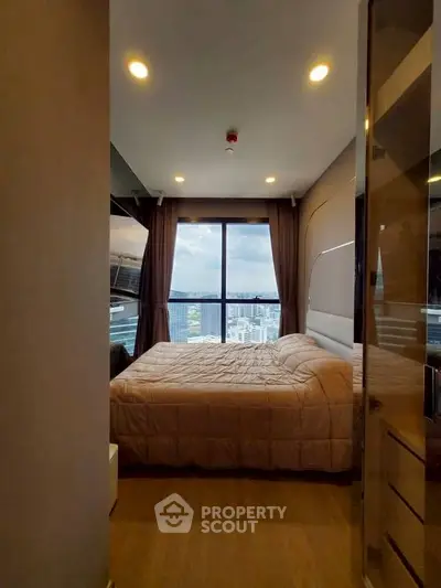 Cozy bedroom with large window offering stunning city view, modern decor, and ambient lighting.