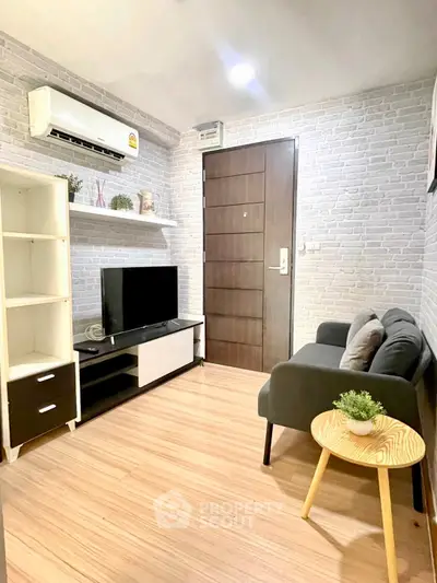 Cozy living room with modern decor, featuring a sleek TV stand, comfortable sofa, and stylish wooden flooring.