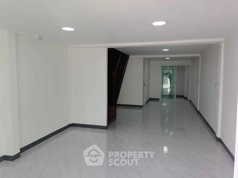Spacious modern interior with sleek flooring and bright lighting, perfect for versatile living space.