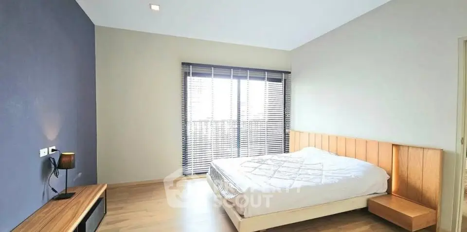 Spacious bedroom with modern design and large window for natural light.