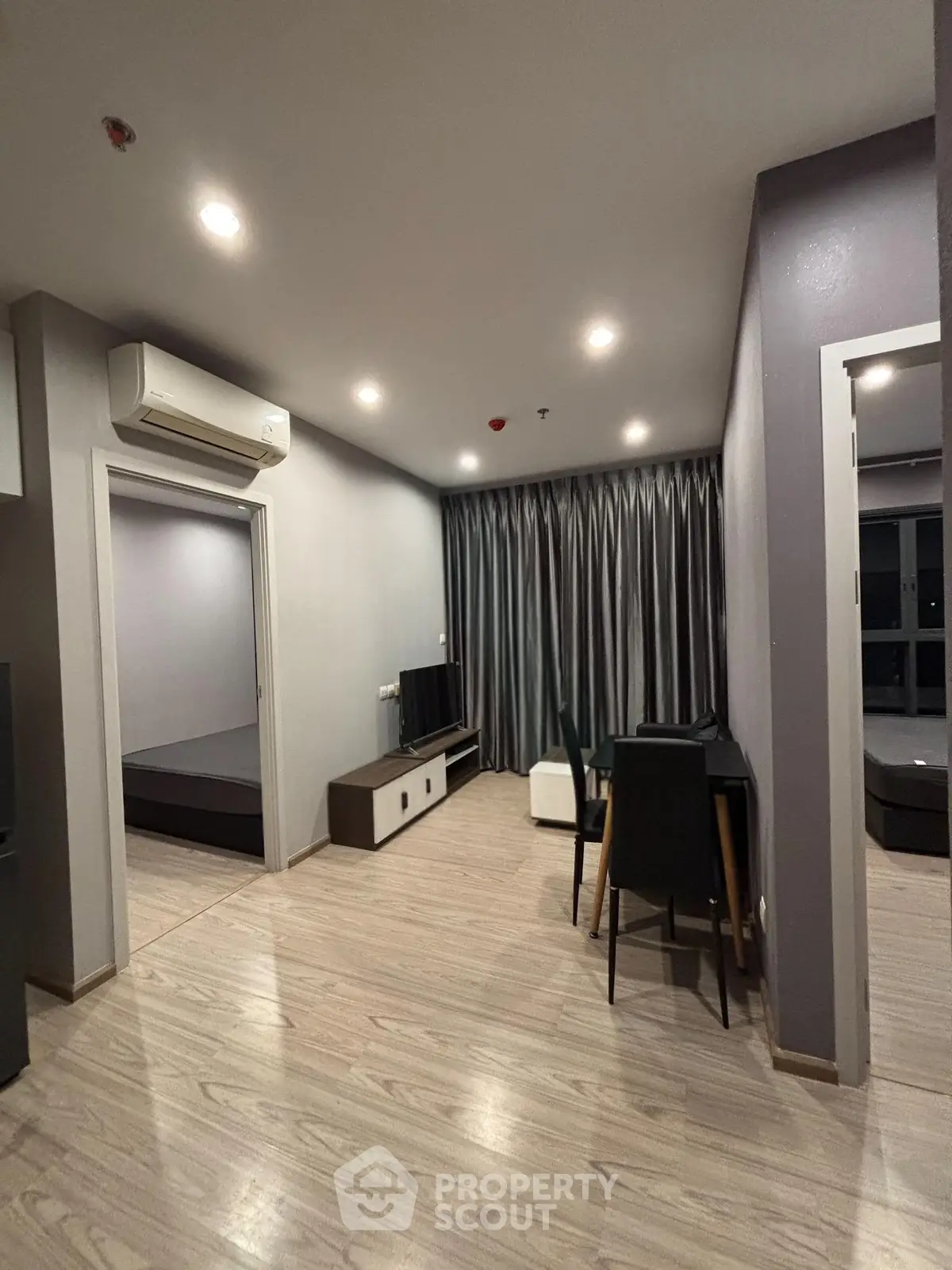 Modern living room with sleek design and wooden flooring, featuring a cozy seating area and stylish decor.