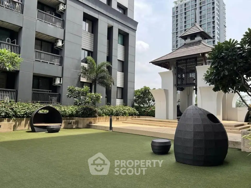Modern apartment building with landscaped garden and unique outdoor seating area.