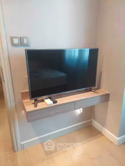 Modern living room with mounted TV and sleek wooden shelf