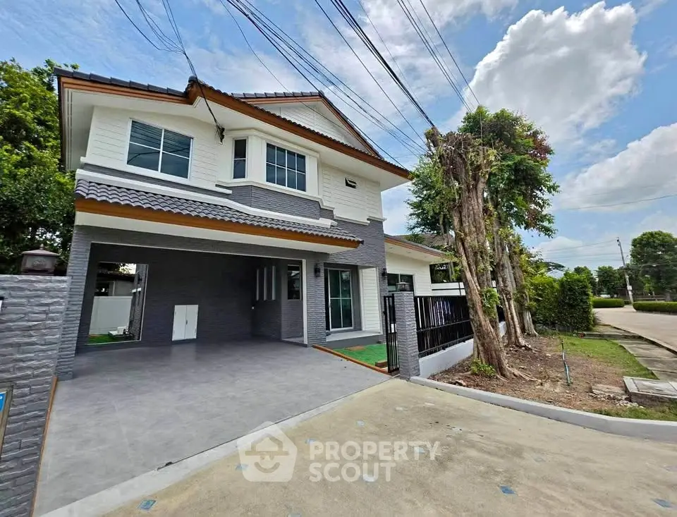 Modern two-story house with spacious driveway and lush greenery, perfect for family living.