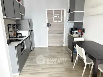 Modern kitchen with sleek cabinetry and dining area in contemporary apartment.