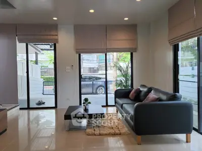 Modern living room with sleek sofa and large windows offering natural light