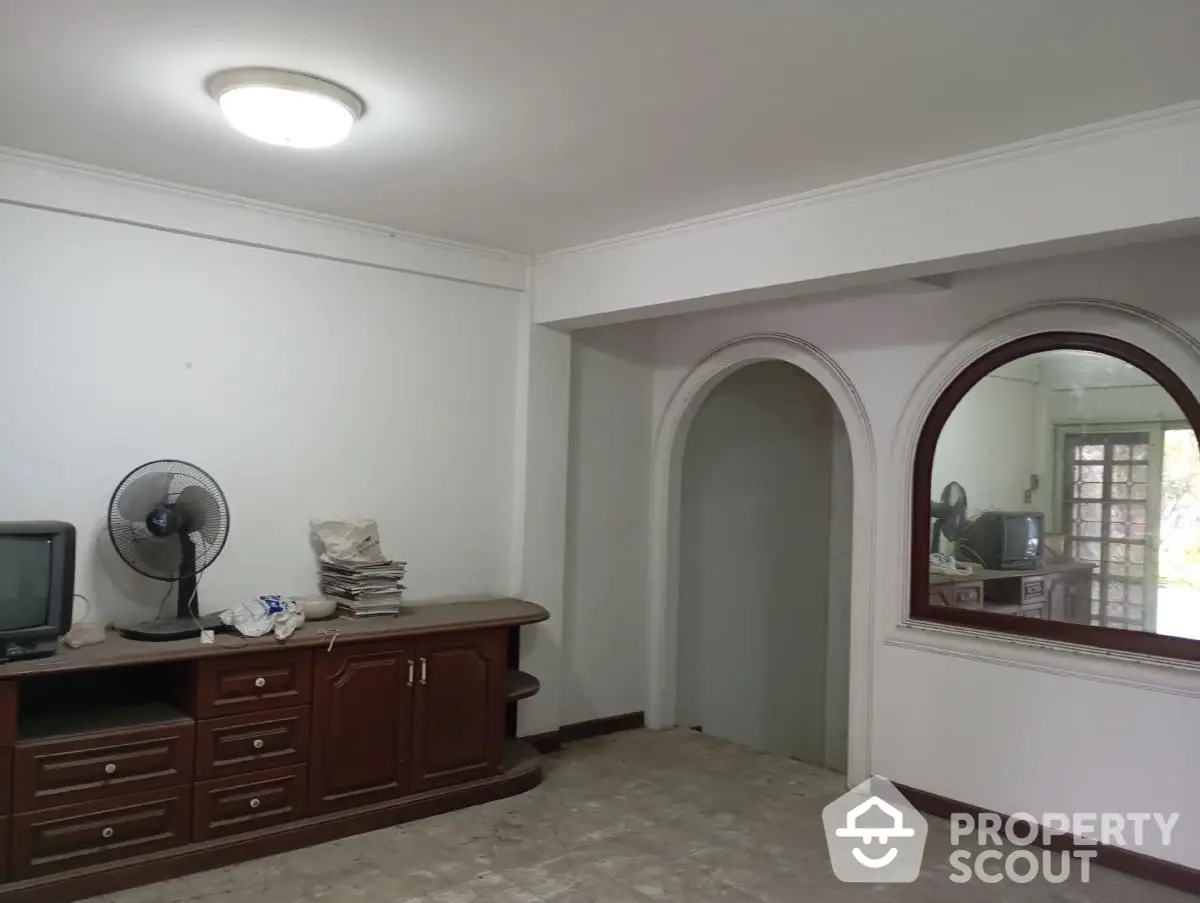 Spacious living room with classic wooden furniture and arched doorway