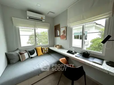 Modern study room with cozy seating and large windows for natural light.
