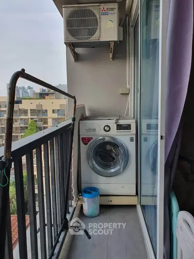 Compact balcony with washing machine and air conditioning unit in urban apartment.