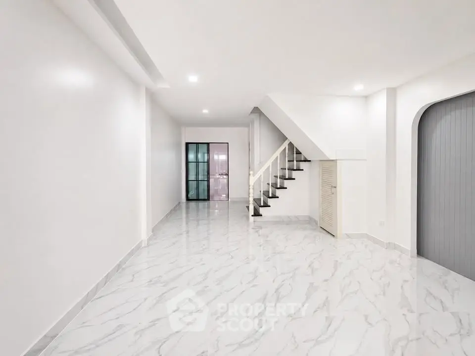 Spacious modern interior with elegant staircase and marble flooring, perfect for stylish living.