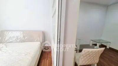 Modern apartment with cozy bedroom and stylish dining area, featuring wooden flooring and elegant furniture.