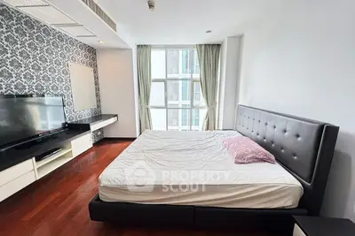 Spacious bedroom with modern decor and large window offering natural light.