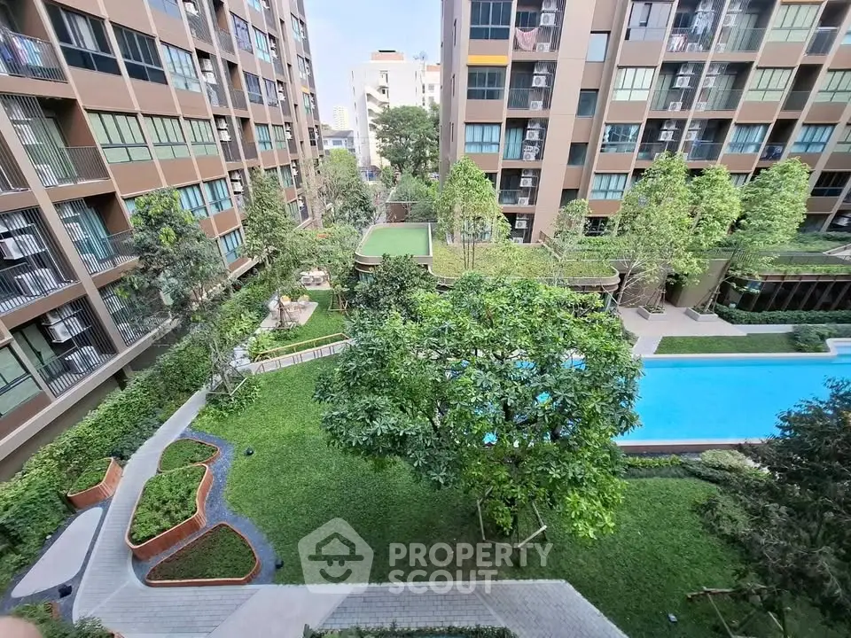 Modern apartment complex with lush garden and pool view