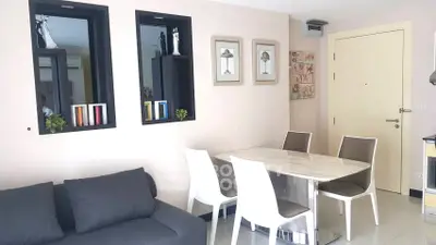 Modern living room with stylish decor and dining area in a cozy apartment.