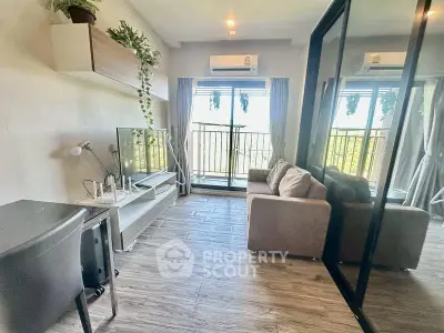 Modern living room with balcony view, featuring sleek furniture and air conditioning.