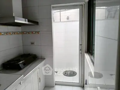 Modern kitchen with gas stove and sleek white tiles