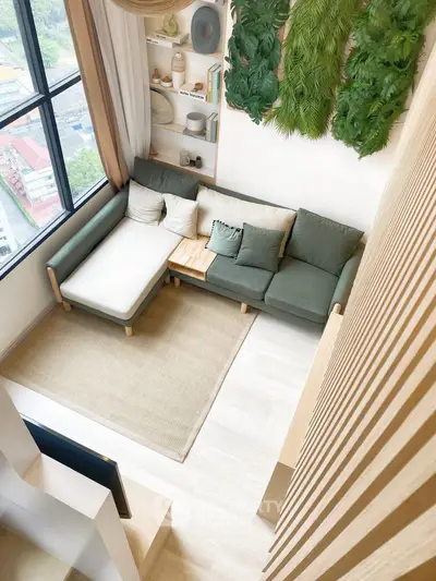 Modern living room with green accents and large window offering city view