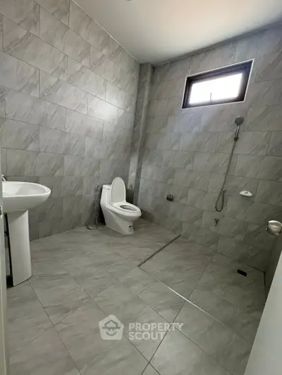 Modern tiled bathroom with shower and toilet in minimalist design