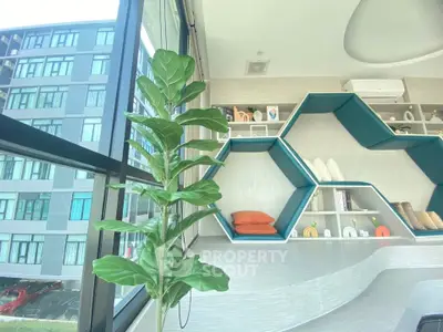Modern apartment interior with stylish shelving and large windows offering a view of the building exterior.