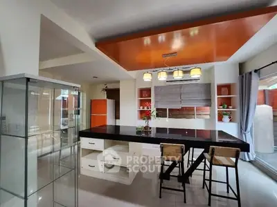 Modern kitchen with sleek black countertop and stylish lighting