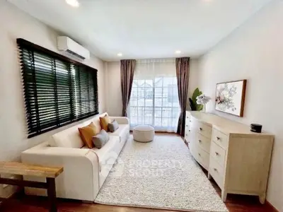 Charming living room with cozy sofa, elegant decor, and large window for natural light.