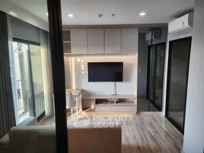 Modern living room with sleek design, featuring a wall-mounted TV and stylish furniture.