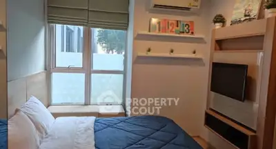 Cozy bedroom with modern decor and large window for natural light.