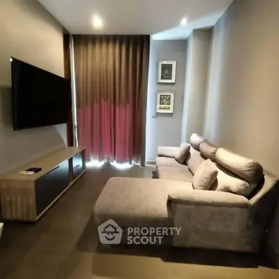 Modern living room with plush sofa and large TV, perfect for relaxation and entertainment.