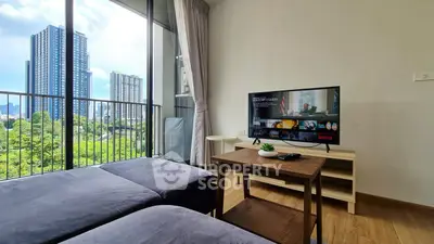Modern living room with balcony view in high-rise apartment, featuring cozy seating and entertainment setup.