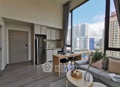 Modern open-plan living room with city view, featuring sleek kitchen and stylish decor.