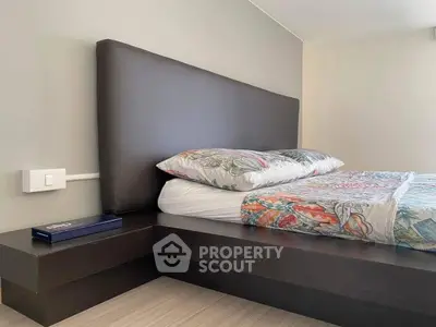 Modern bedroom with stylish headboard and colorful bedding in a contemporary apartment.