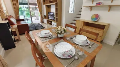 Charming dining area with elegant table setting and cozy living room view.