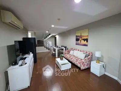 Spacious living room with modern decor and wooden flooring in a stylish apartment.