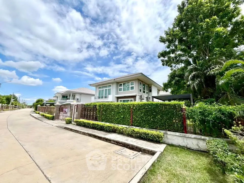 Charming suburban house with lush greenery and clear blue sky, perfect for family living.