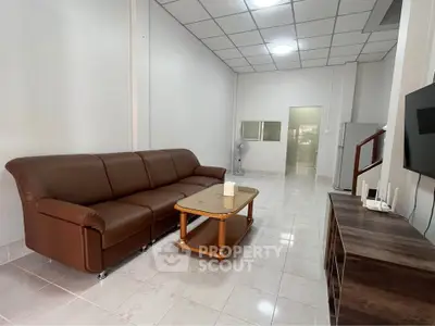 Spacious living room with brown leather sofa and modern decor