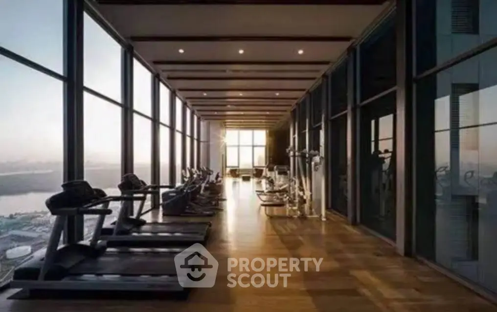 Luxurious high-rise gym with panoramic city views and modern fitness equipment.