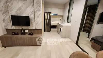 Modern apartment with open layout, featuring a sleek kitchen and cozy living area.