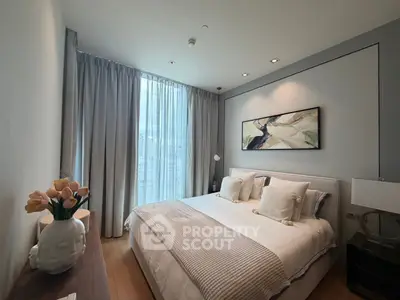 Luxurious bedroom with modern decor and large window offering natural light